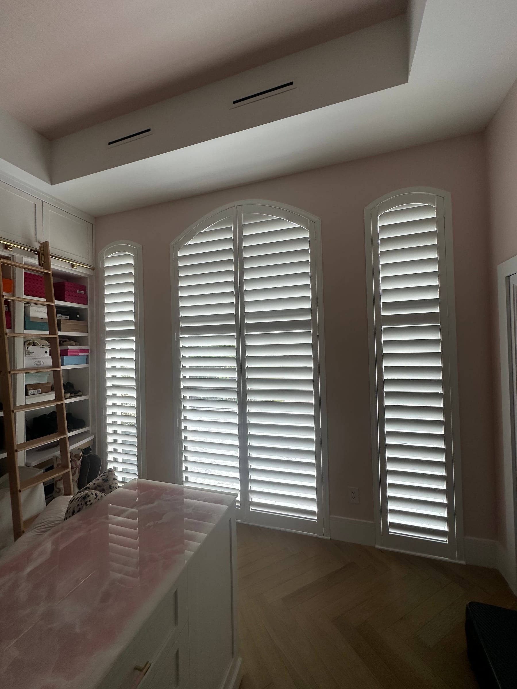 White shutters with arched tops on three tall windows