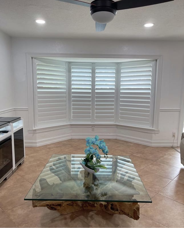 White shutters following the angles of a three-sided bay window